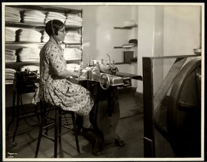 Mulher cega, presumivelmente Charlotte Rohr, trabalhando com uma prensa braille, ditafone e estereótipo, Nova York, 1933 (impressão em gelatina de prata)